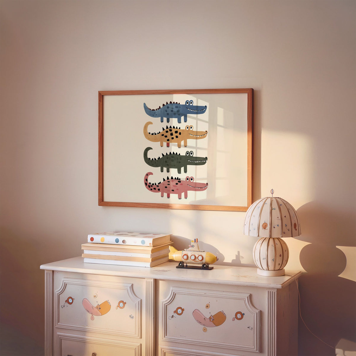 Landscape four stacked crocodiles nursery print in a cherry wood frame above a painted dresser and lamp