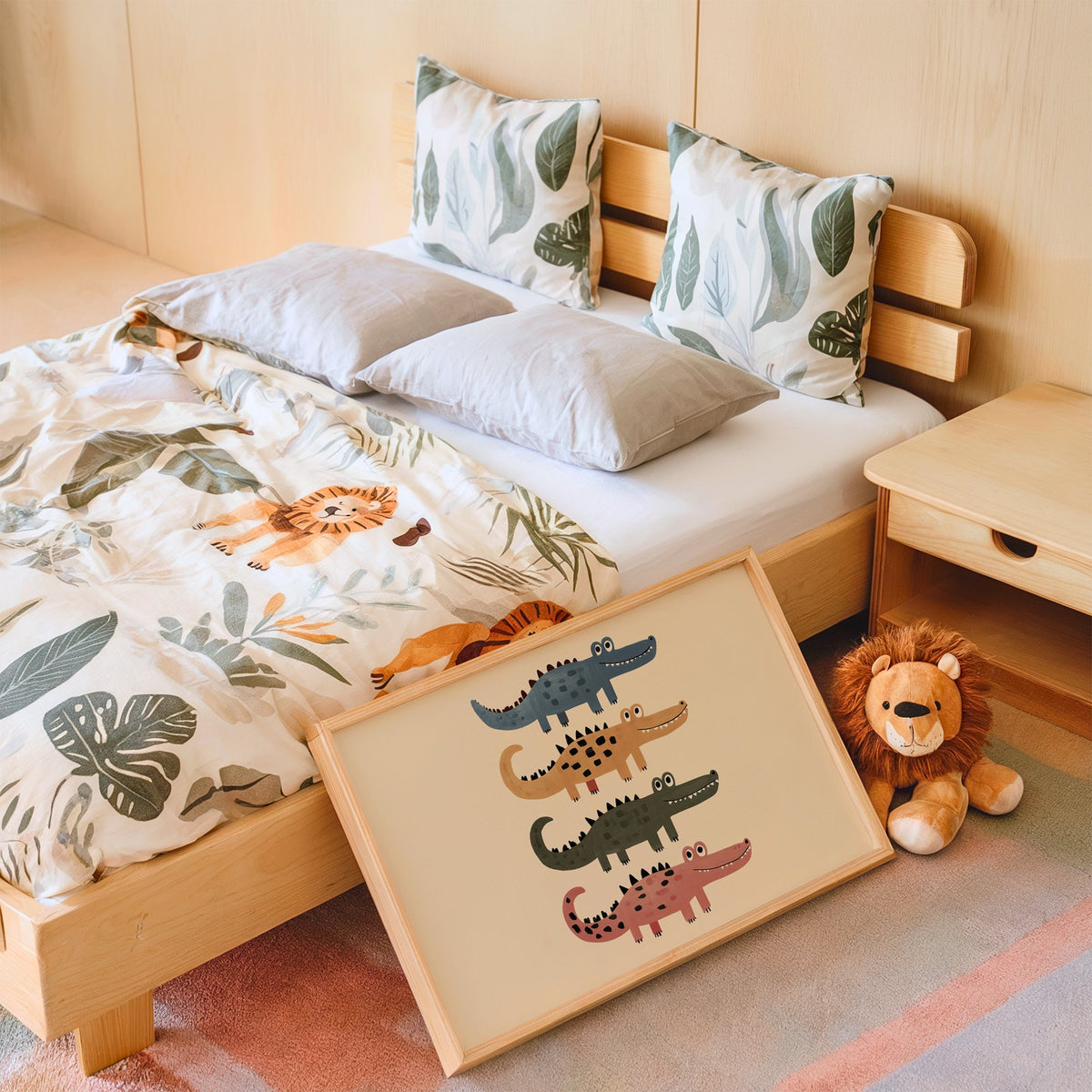 Landscape four stacked crocodiles nursery print in an oak frame leaning on a kids bed by a lion plush