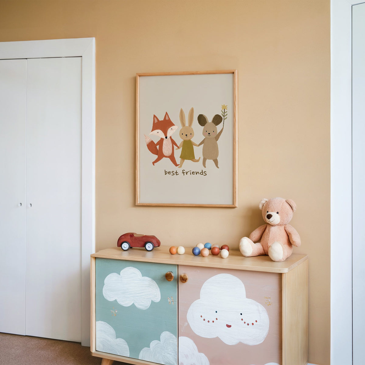 Fox bunny mouse best friends nursery print in an oak frame on a peach wall above a cloud-painted cabinet
