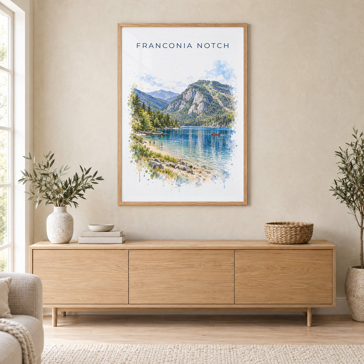 Franconia Notch watercolor print in an oak frame above a light wood sideboard in a Scandinavian living room