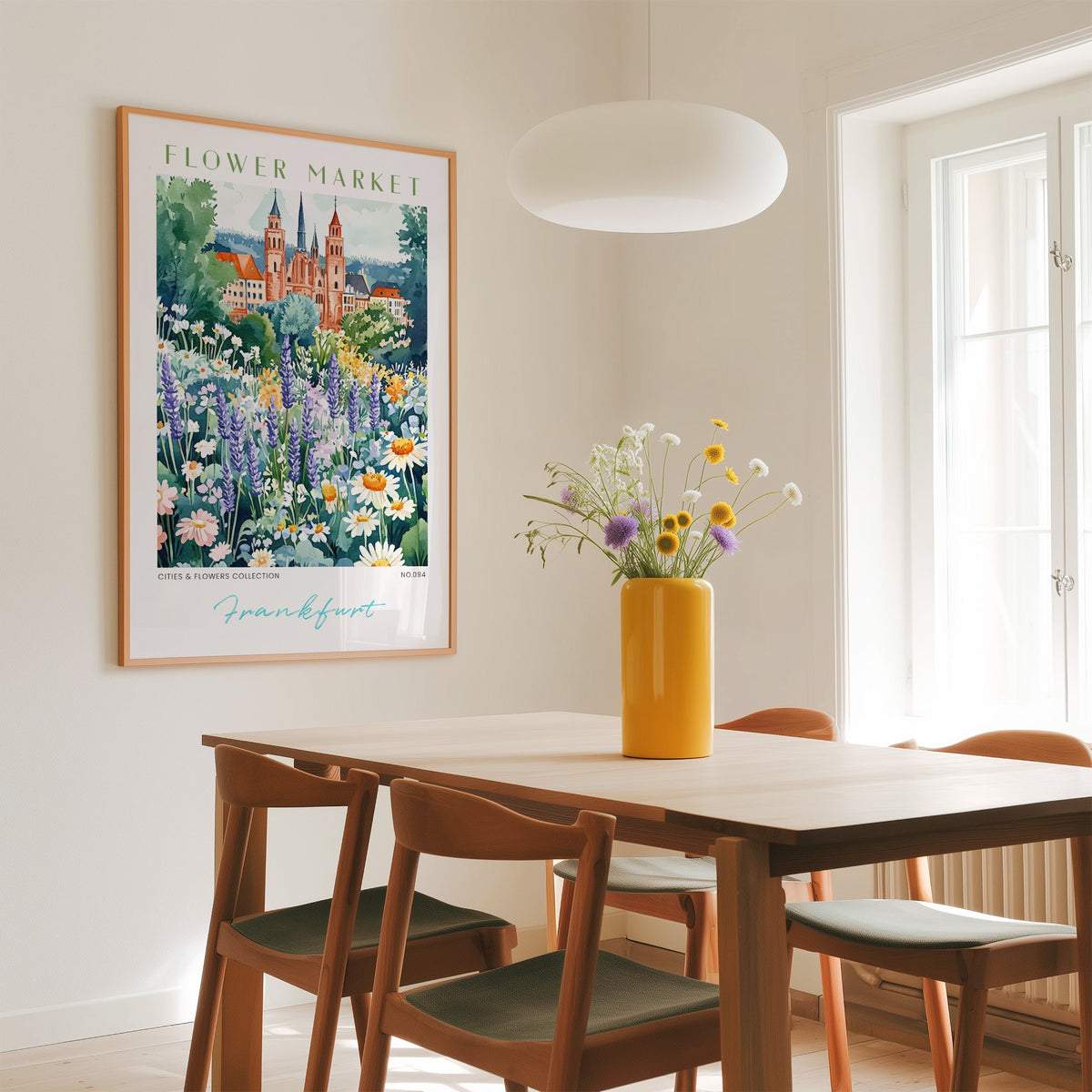 Frankfurt flower market print in an oak frame above a dining table with a yellow vase and white pendant light