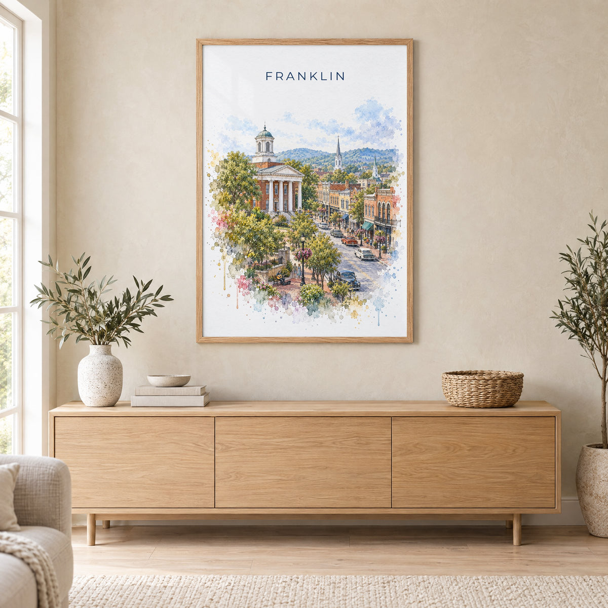 Franklin, Tennessee watercolor print in an oak frame above a light wood sideboard in a Scandinavian living room