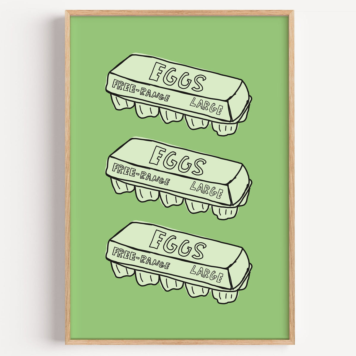 Free range eggs carton print in a light oak frame on a plain white wall