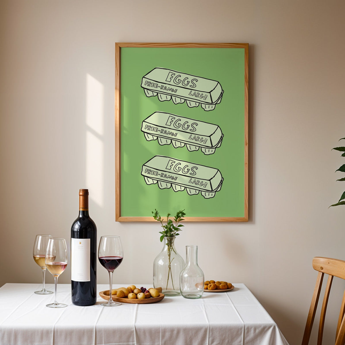 Free range eggs carton print in an oak frame above a table laid with red wine and glasses