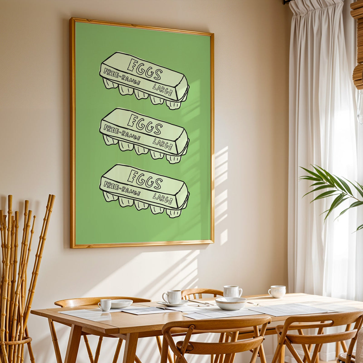 Free range eggs carton print in a gold frame above a sunlit breakfast table