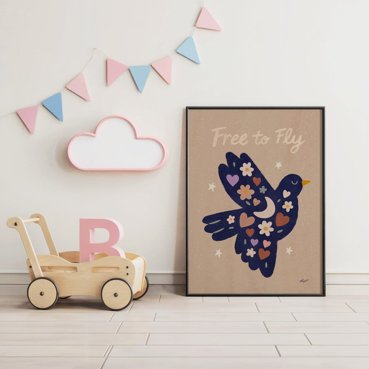 Navy folk bird free to fly nursery print in a black frame under pastel bunting by a wooden baby walker