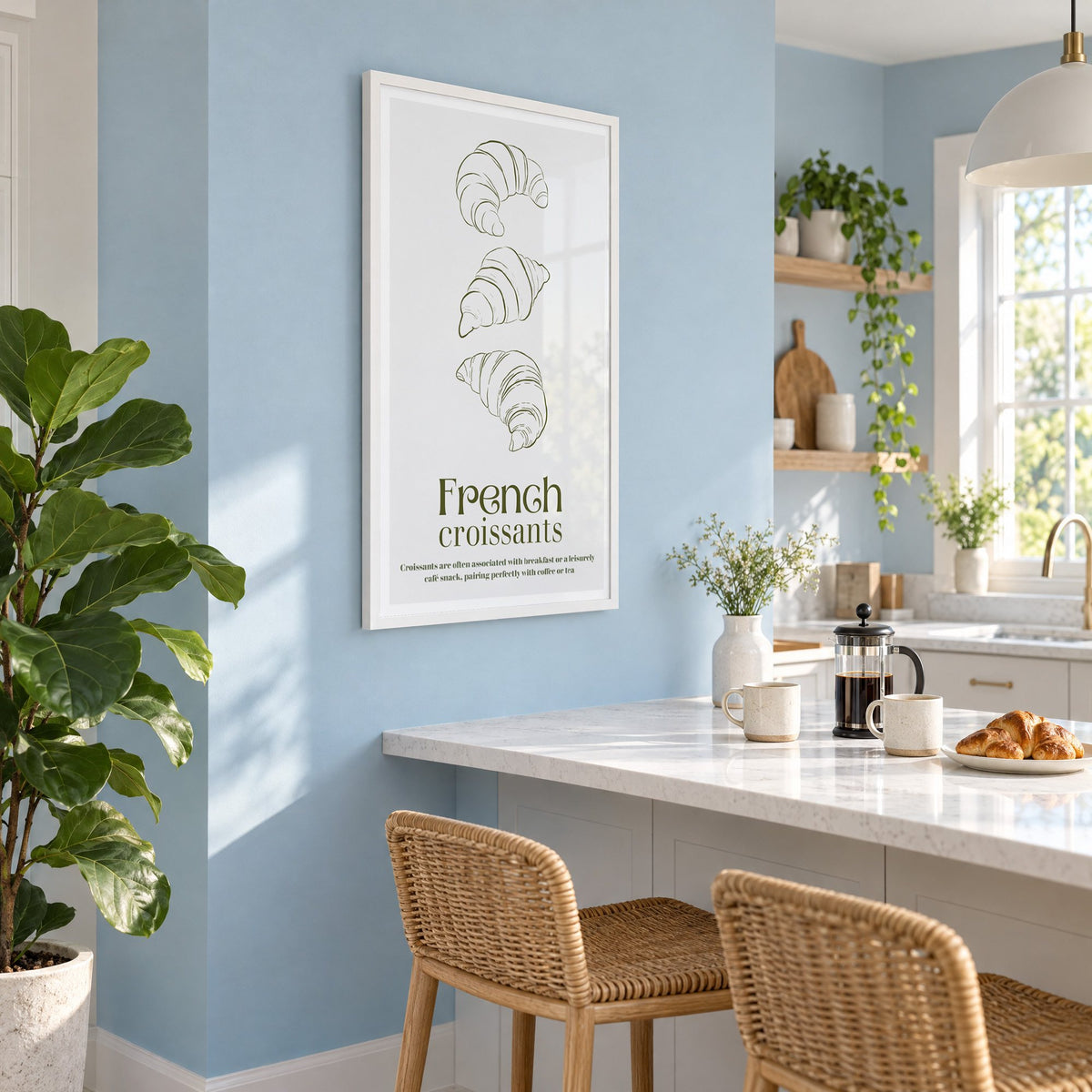 French croissants olive line print in a white frame on a pale blue wall above a breakfast bar with rattan stools