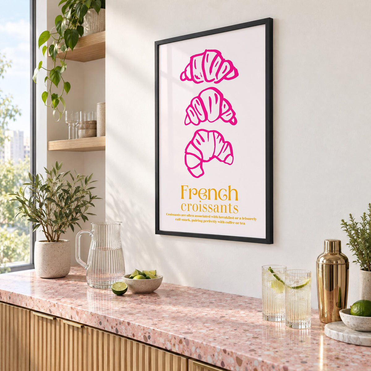 French croissants hot pink line print in a black frame above a pink terrazzo cocktail counter with limes, seen at an angle