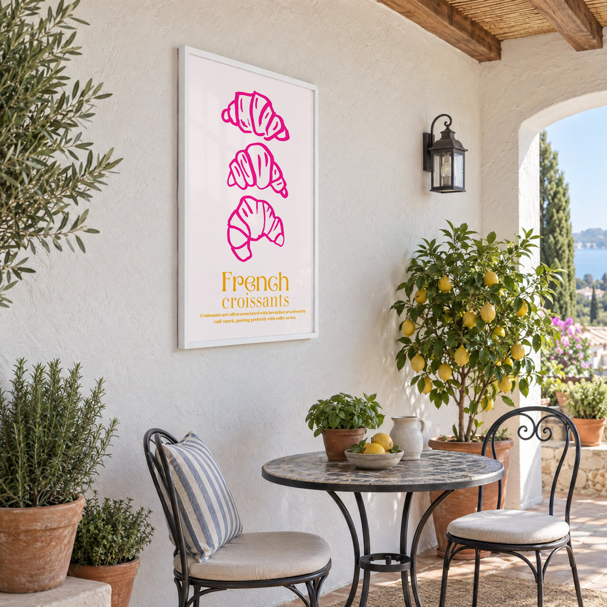 French croissants hot pink line print in a white frame on a sunny patio wall beside a potted lemon tree