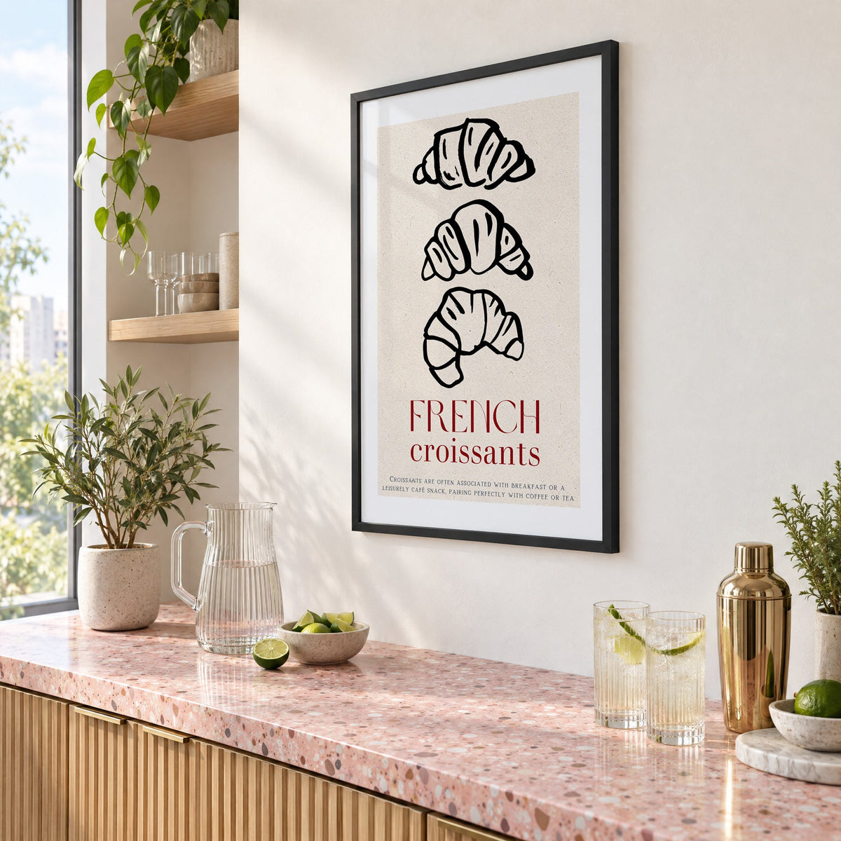 FRENCH croissants black line-art print in a black frame above a pink terrazzo cocktail counter with limes, seen at an angle