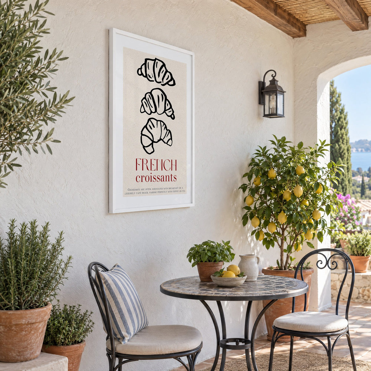 FRENCH croissants black line-art print in a white frame on a sunny patio wall beside a potted lemon tree