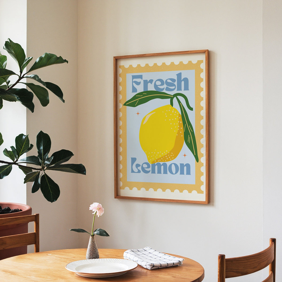 Fresh Lemon stamp print in a walnut frame above a round table beside a fiddle-leaf fig