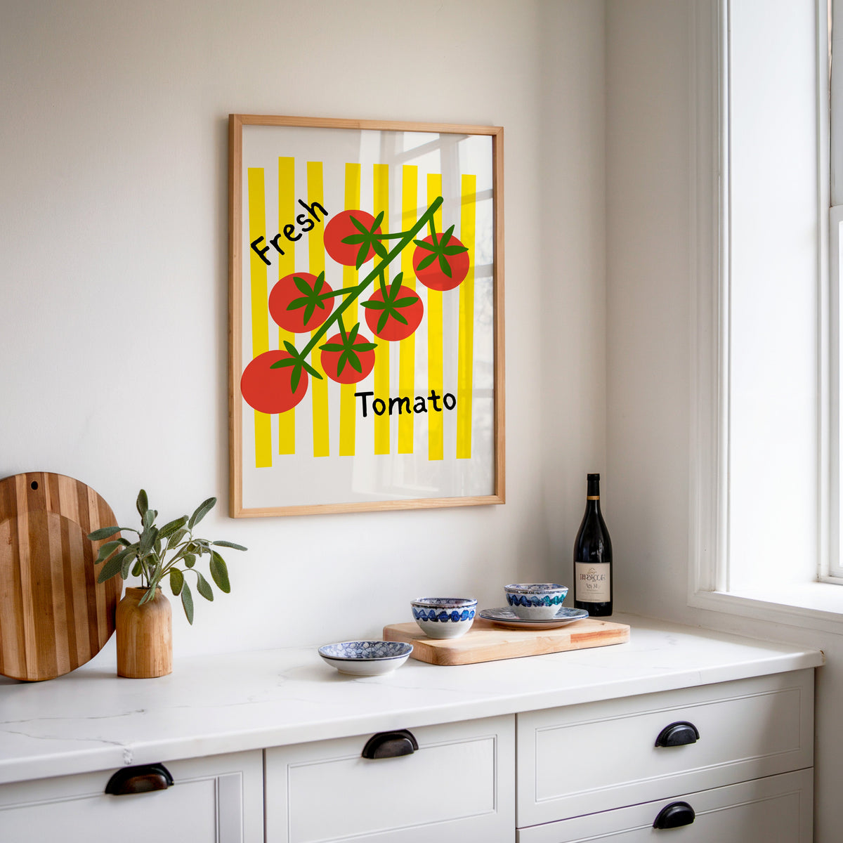Fresh Tomato print in an oak frame above a white sideboard with a bottle of wine