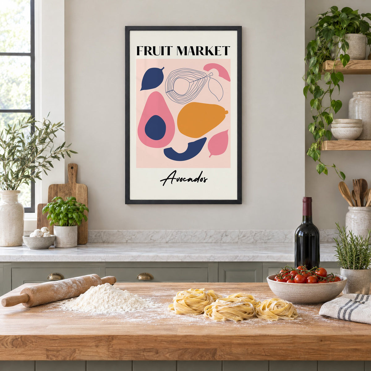 FRUIT MARKET Avocados cut-paper print in a black frame above a butcher-block island with fresh pasta, flour and cherry tomatoes