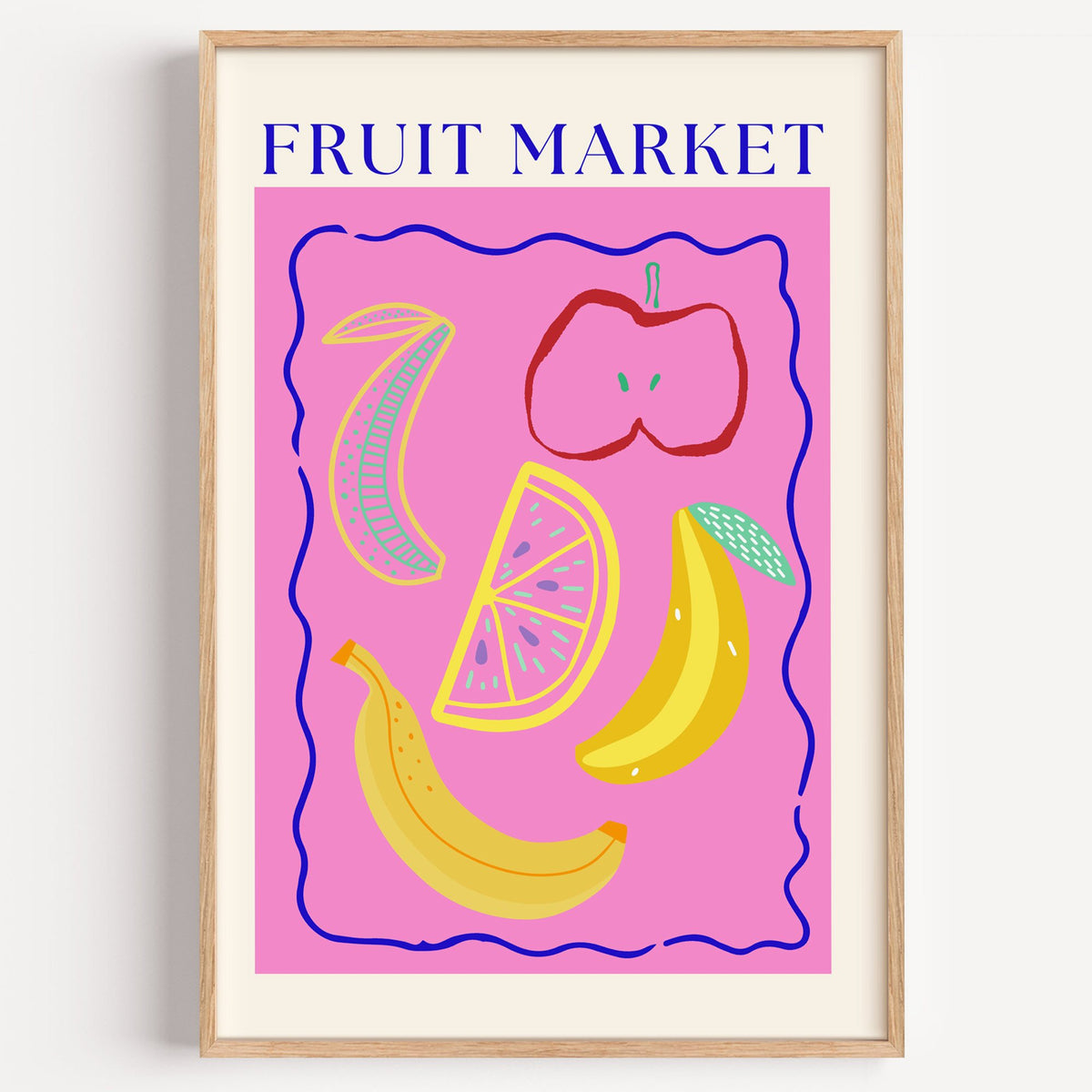 FRUIT MARKET bananas, apple and citrus print in a light oak frame on a plain white wall