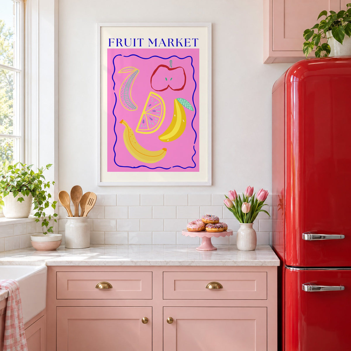 FRUIT MARKET bananas, apple and citrus print in a white frame above pink cabinets beside a red retro fridge