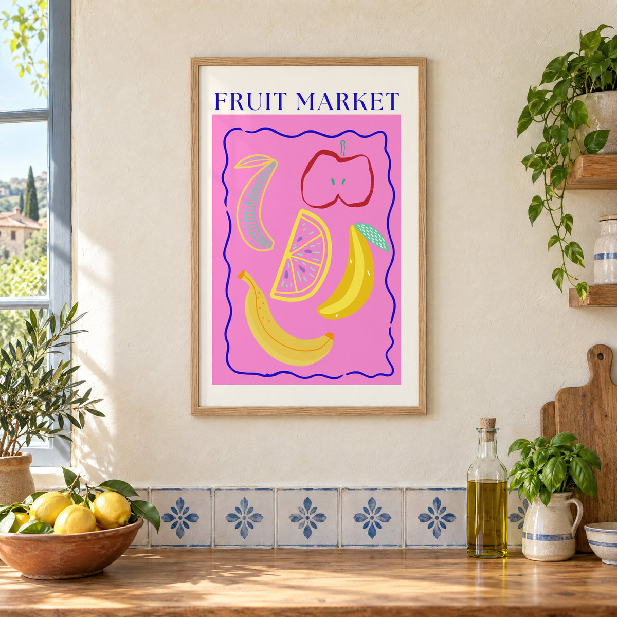 FRUIT MARKET bananas, apple and citrus print in an oak frame on a cream plaster wall above a worktop with a bowl of lemons and blue-and-white tiles
