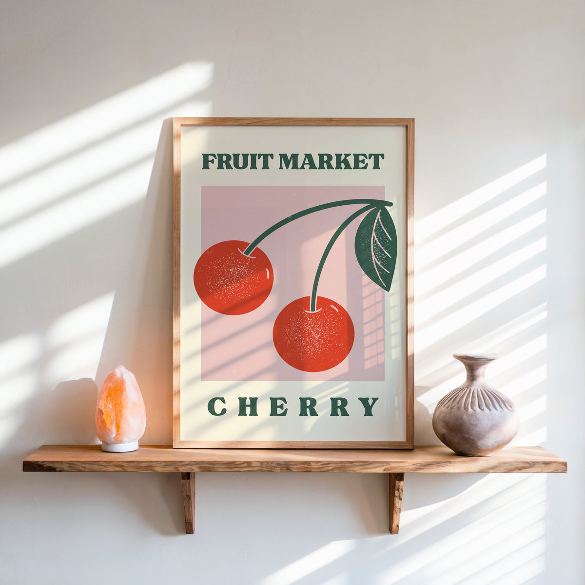 Fruit Market cherry print in an oak frame on a live-edge shelf beside a salt lamp