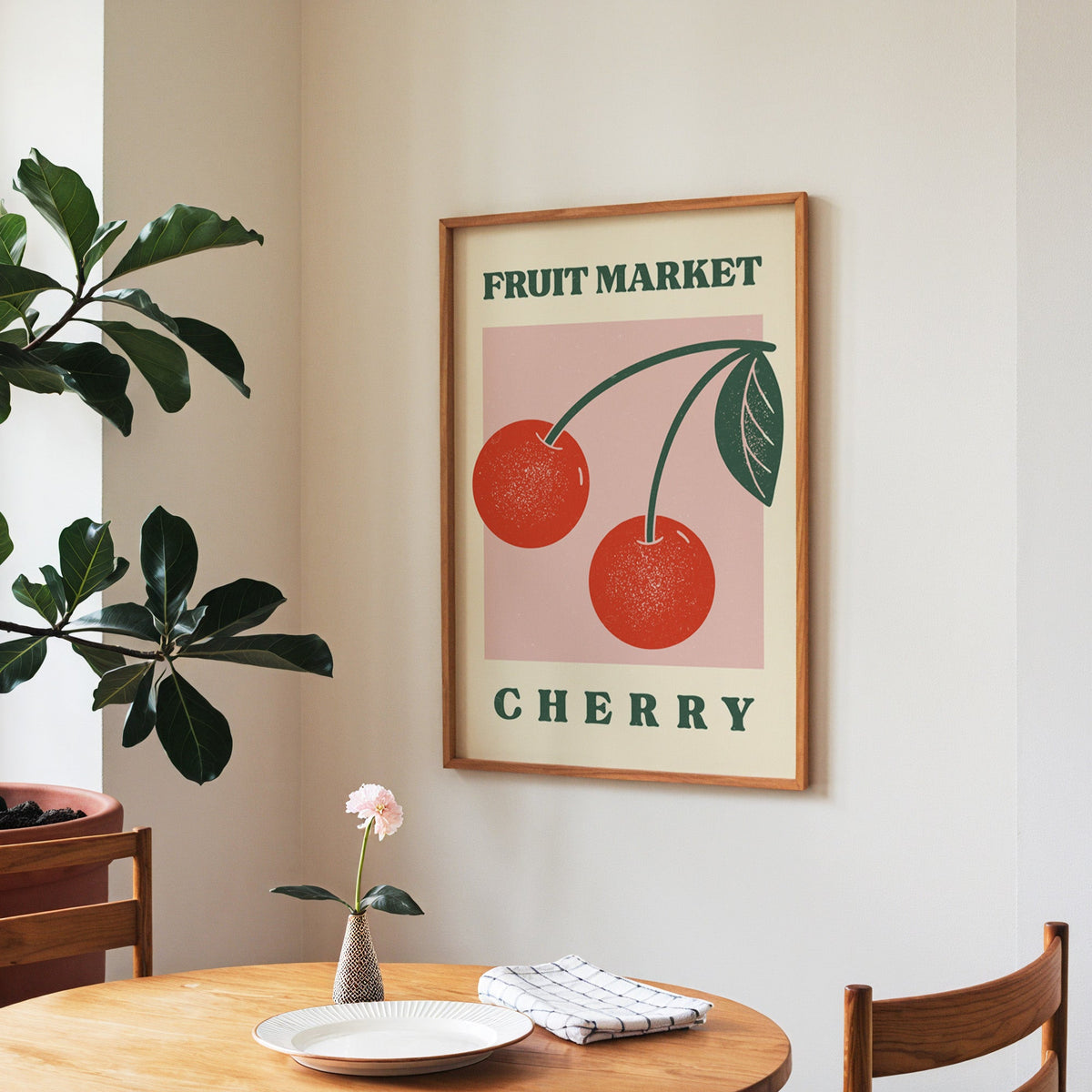 Fruit Market cherry print in a walnut frame above a round table beside a fiddle-leaf fig