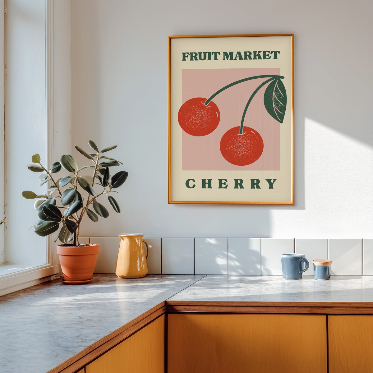 Fruit Market cherry print shown in a gold frame above a marble counter in a tan kitchen