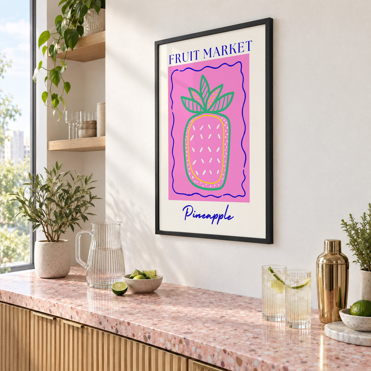 FRUIT MARKET Pineapple pink wavy frame print in a black frame above a pink terrazzo cocktail counter with limes, seen at an angle