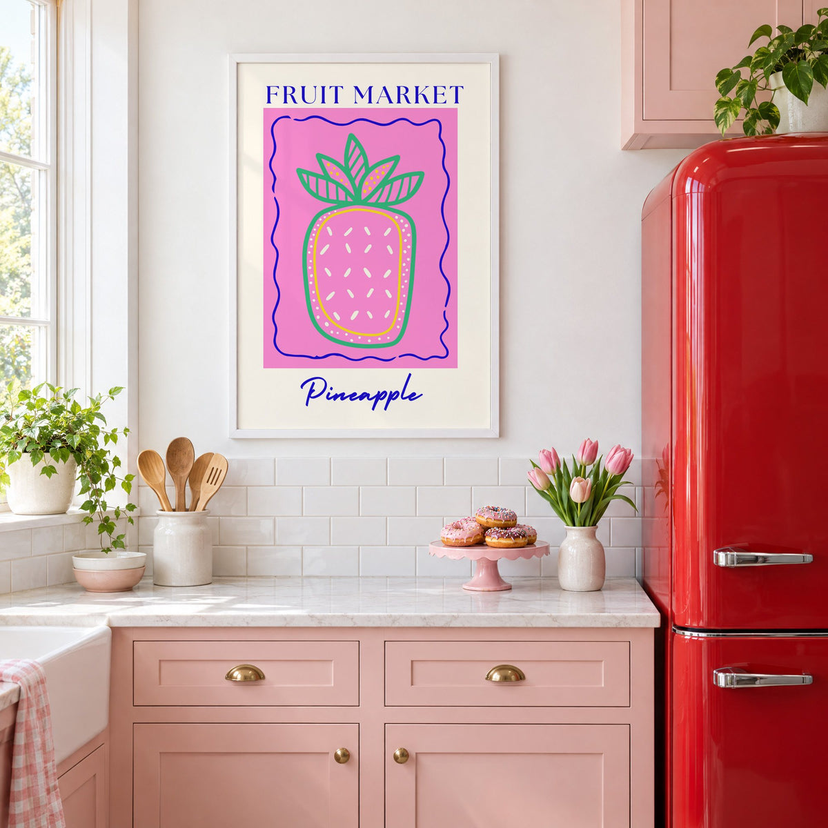 FRUIT MARKET Pineapple pink wavy frame print in a white frame above pink cabinets beside a red retro fridge
