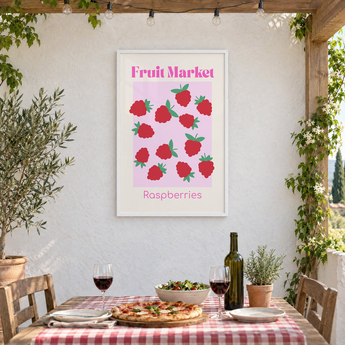 Fruit Market Raspberries pink panel print in a white frame on a stucco wall above a checked-cloth table with pizza and red wine
