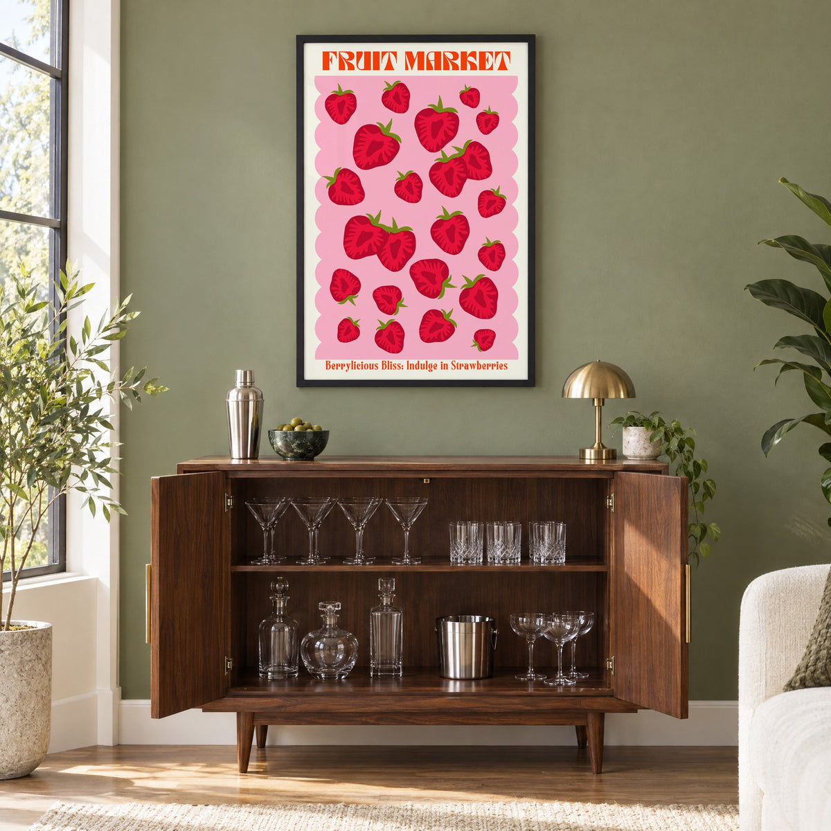 FRUIT MARKET strawberries pink scallop print in a black frame on an olive green wall above a walnut bar cabinet with glassware