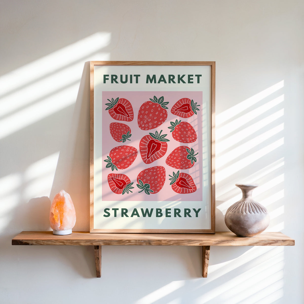 Fruit Market strawberry print in an oak frame on a live-edge shelf beside a salt lamp