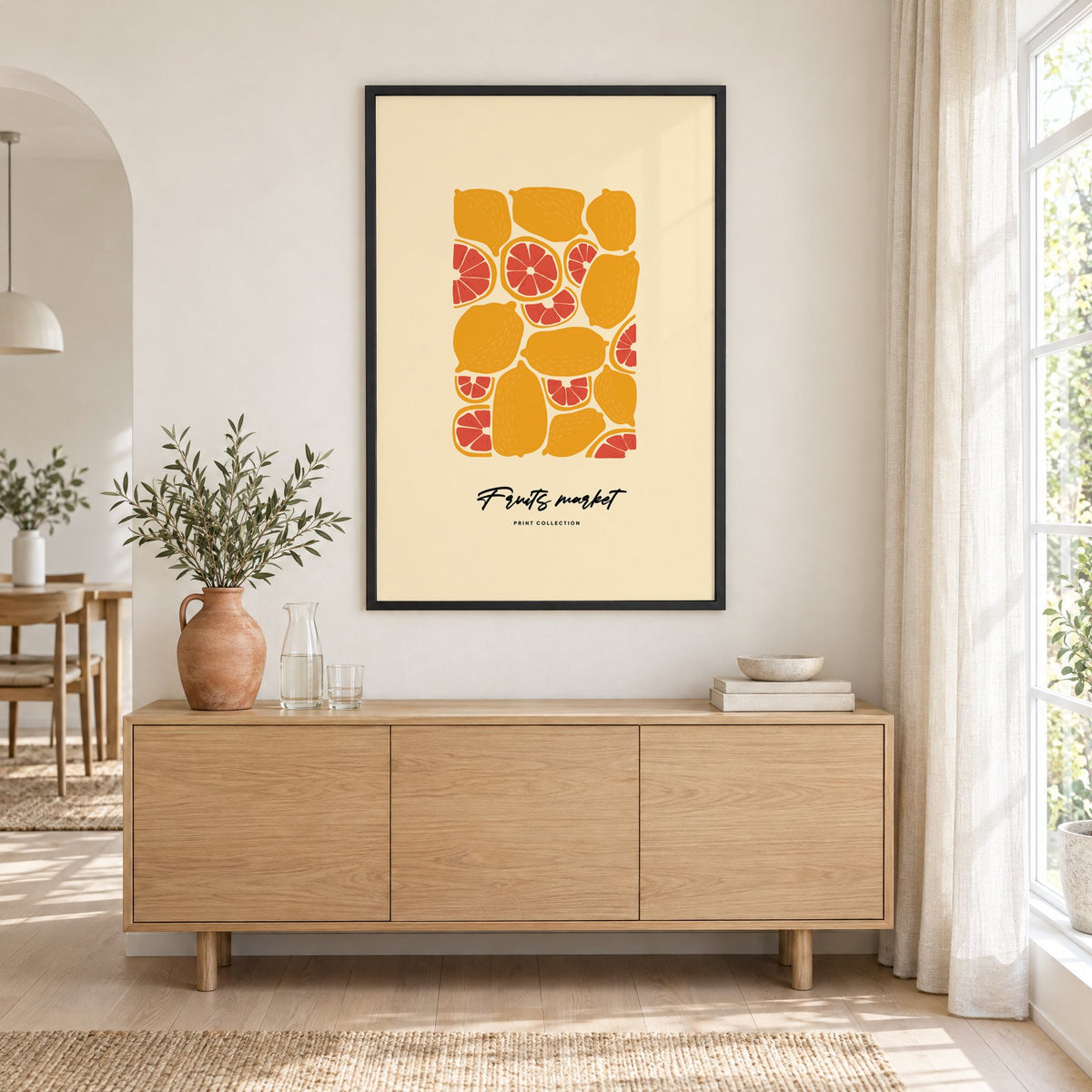 Fruits market citrus pattern print in a black frame above an oak sideboard with a terracotta vase of olive branches