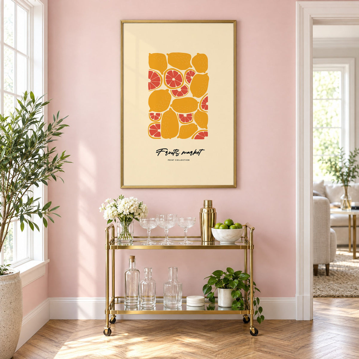 Fruits market citrus pattern print in a brass frame above a gold bar cart on a blush pink wall