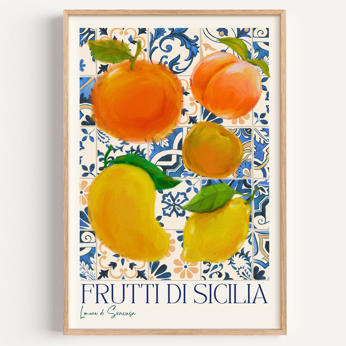 Frutti di Sicilia blue tile fruit print in a light oak frame on a plain white wall