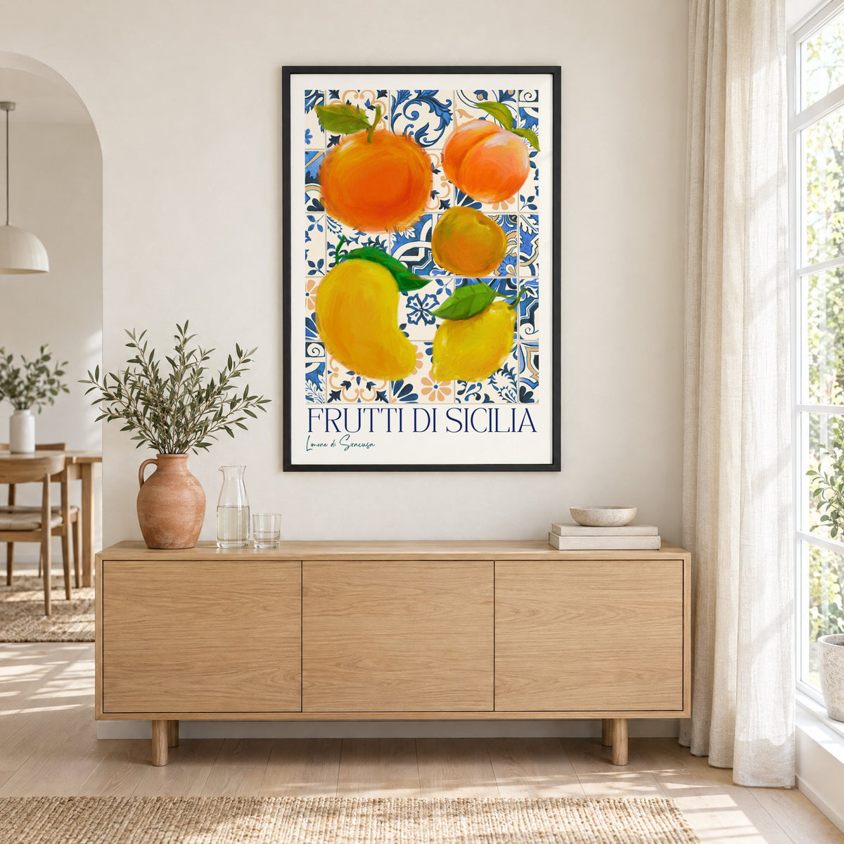 Frutti di Sicilia blue tile fruit print in a black frame above an oak sideboard with a terracotta vase of olive branches