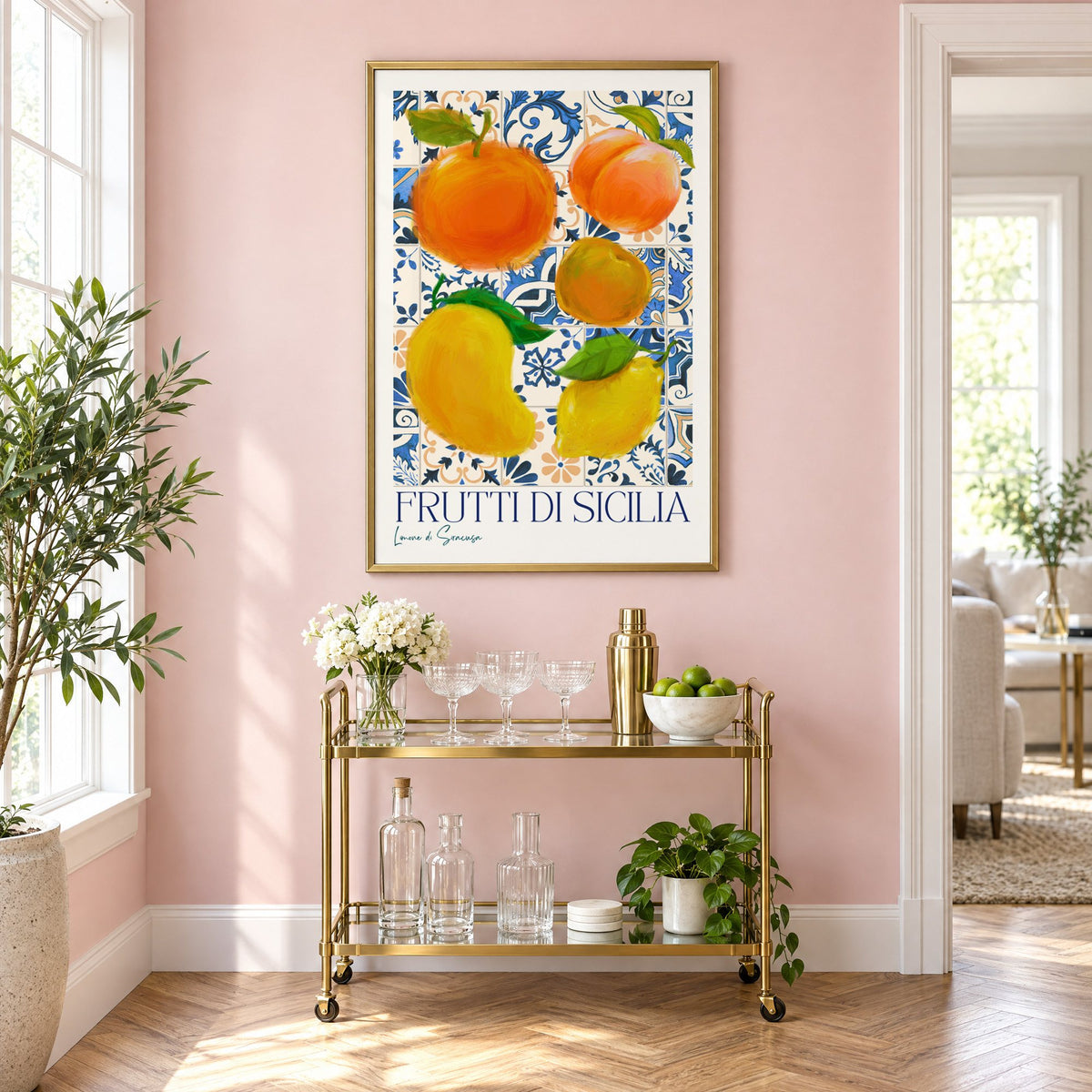 Frutti di Sicilia blue tile fruit print in a brass frame above a gold bar cart on a blush pink wall
