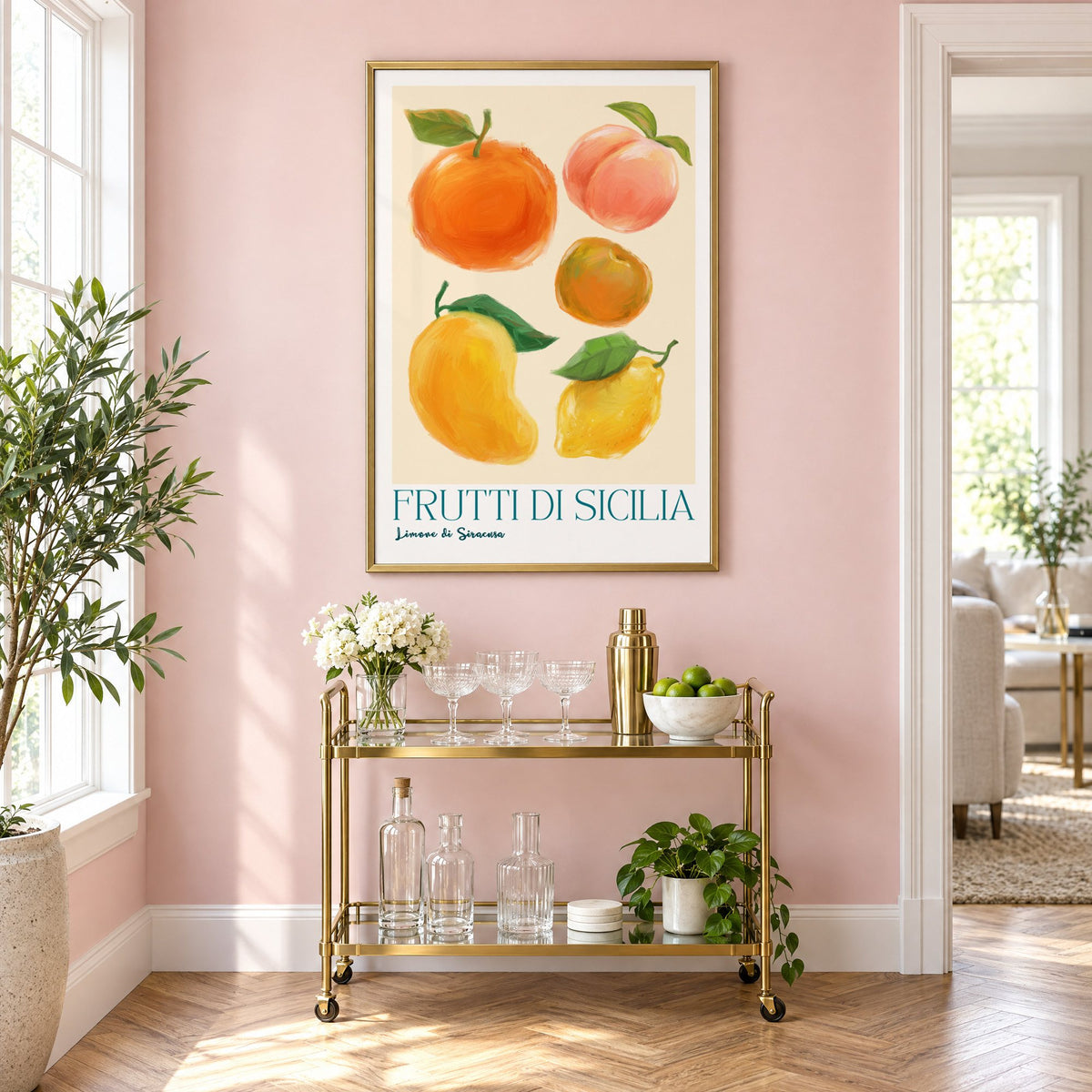 Frutti di Sicilia cream painted fruit print in a brass frame above a gold bar cart on a blush pink wall