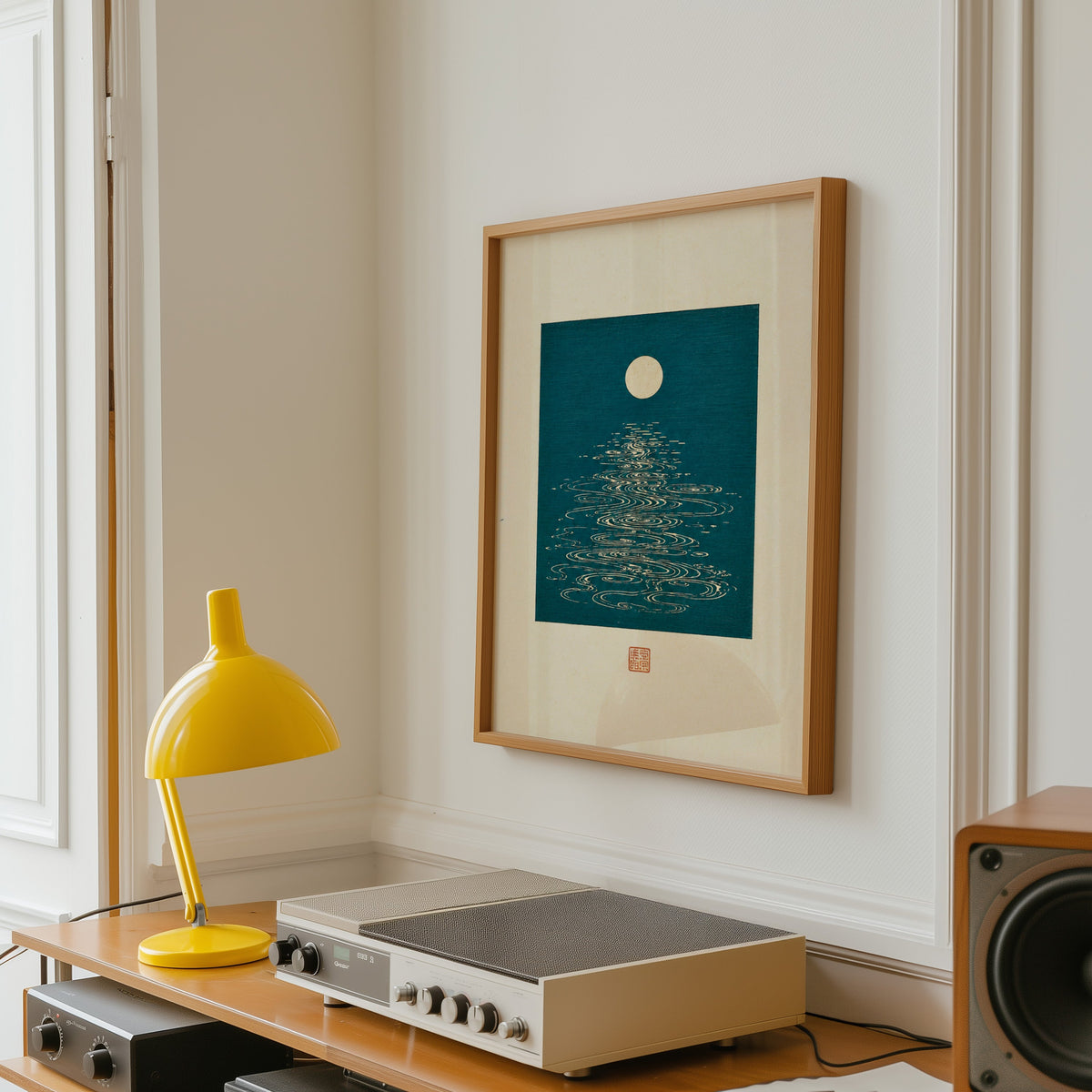 full moon over teal water print in an oak frame above a vintage hi-fi shelf with a yellow desk lamp
