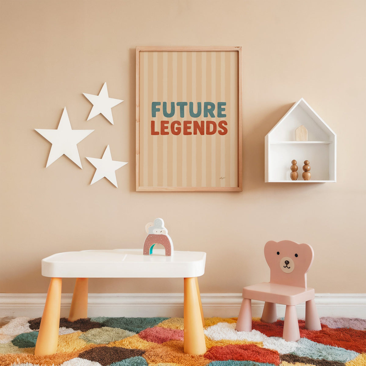 Future legends retro lettering nursery print in an oak frame on a peach wall above a kids table with wall stars