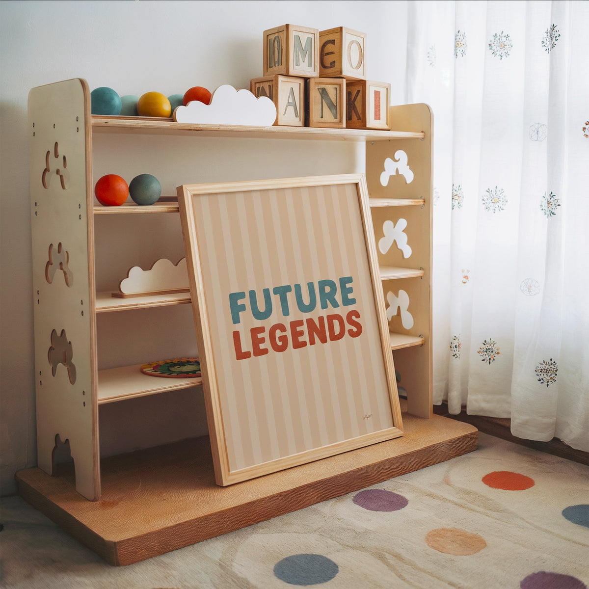 Future legends retro lettering nursery print in an oak frame leaning on a toy shelf with wooden letter blocks