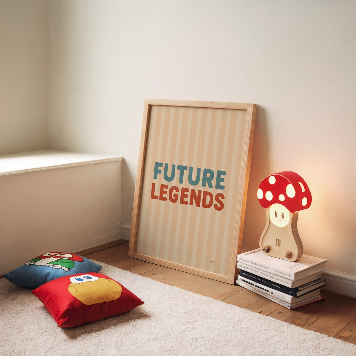 Future legends retro lettering nursery print in an oak frame leaning on a rug beside a mushroom lamp and floor cushions