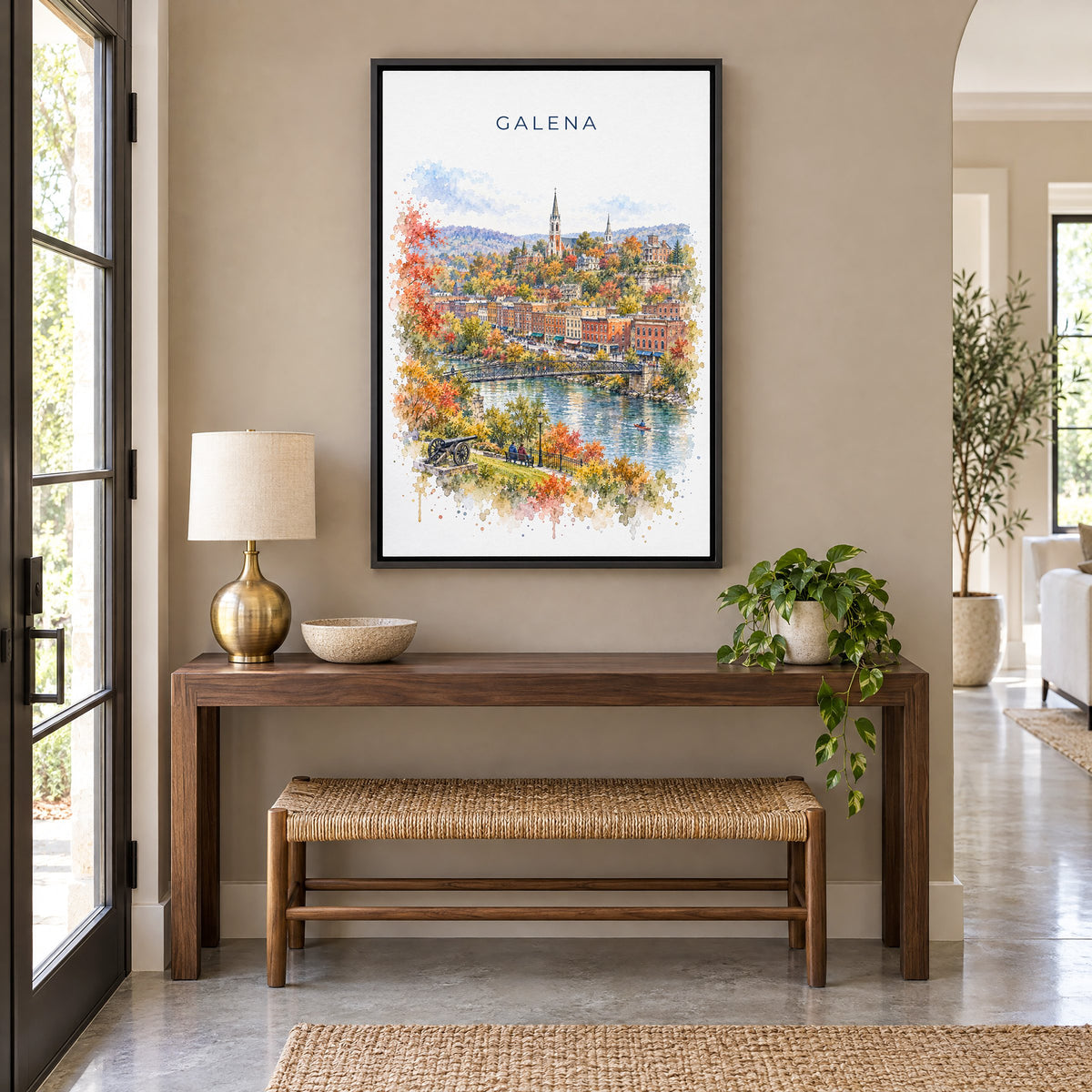 Galena, Illinois watercolor print as a black floater canvas above a walnut console and woven bench in an entryway