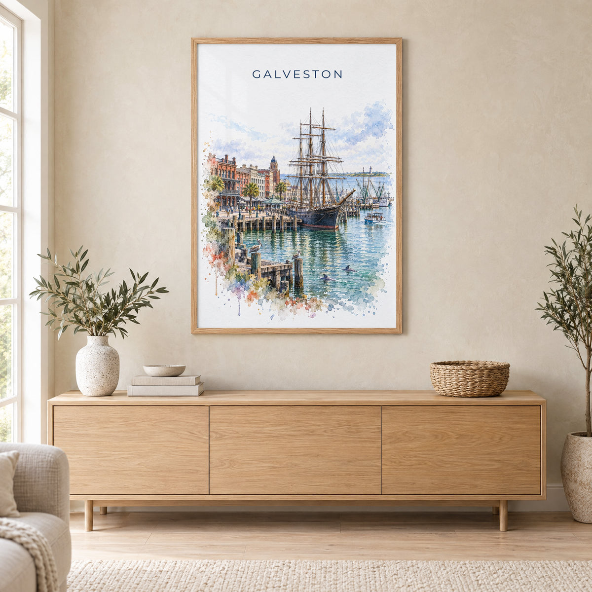 Galveston watercolor print in an oak frame above a light wood sideboard in a Scandinavian living room