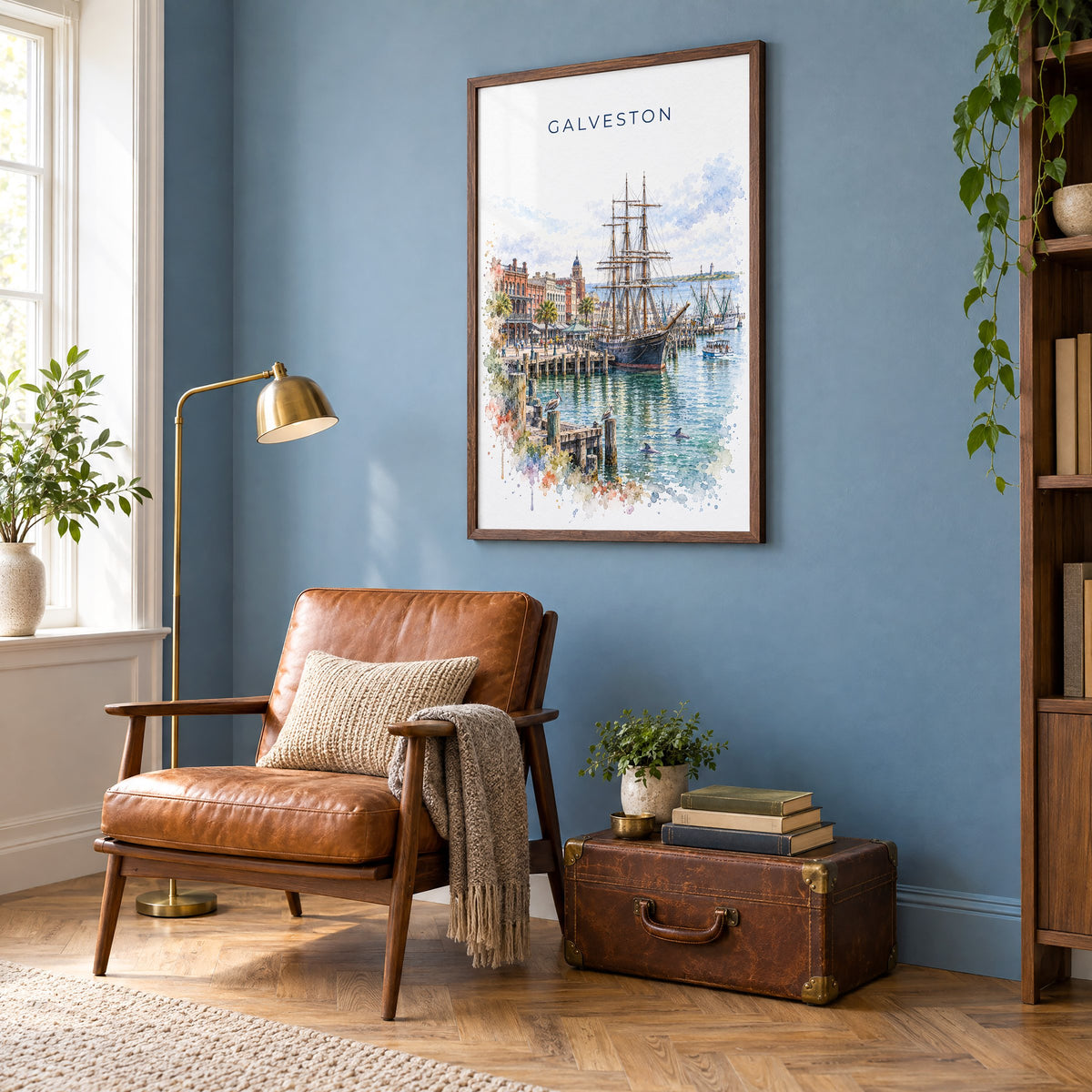 Galveston watercolor print in a walnut frame on a blue wall above a leather armchair in a reading nook