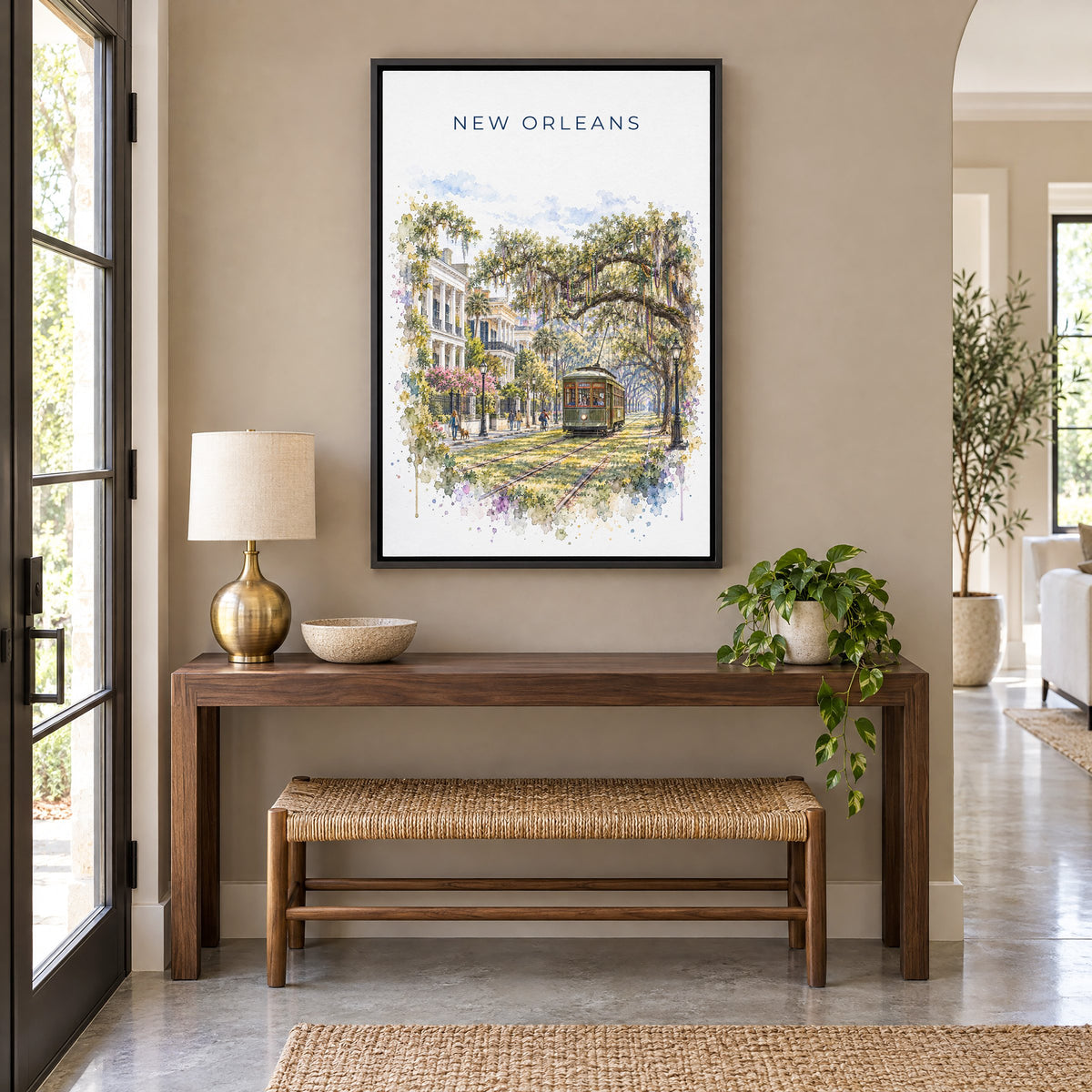 Garden District New Orleans watercolor print as a black floater canvas above a walnut console and woven bench in an entryway