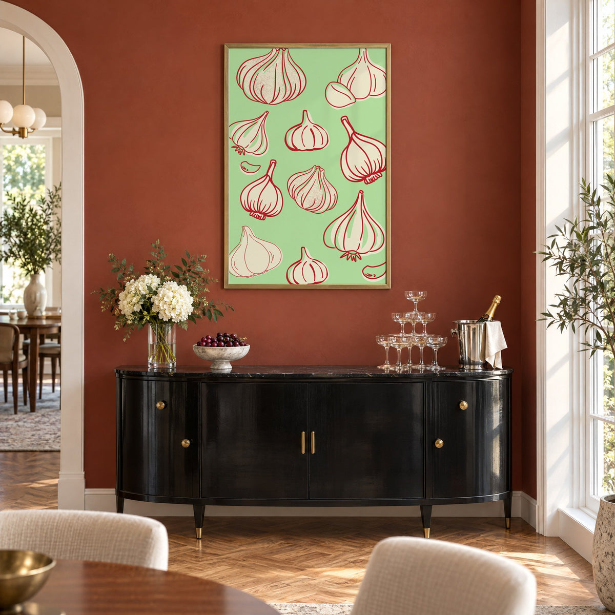 Garlic bulbs red line mint pattern in a brass frame on a terracotta wall above a black buffet with a champagne tower