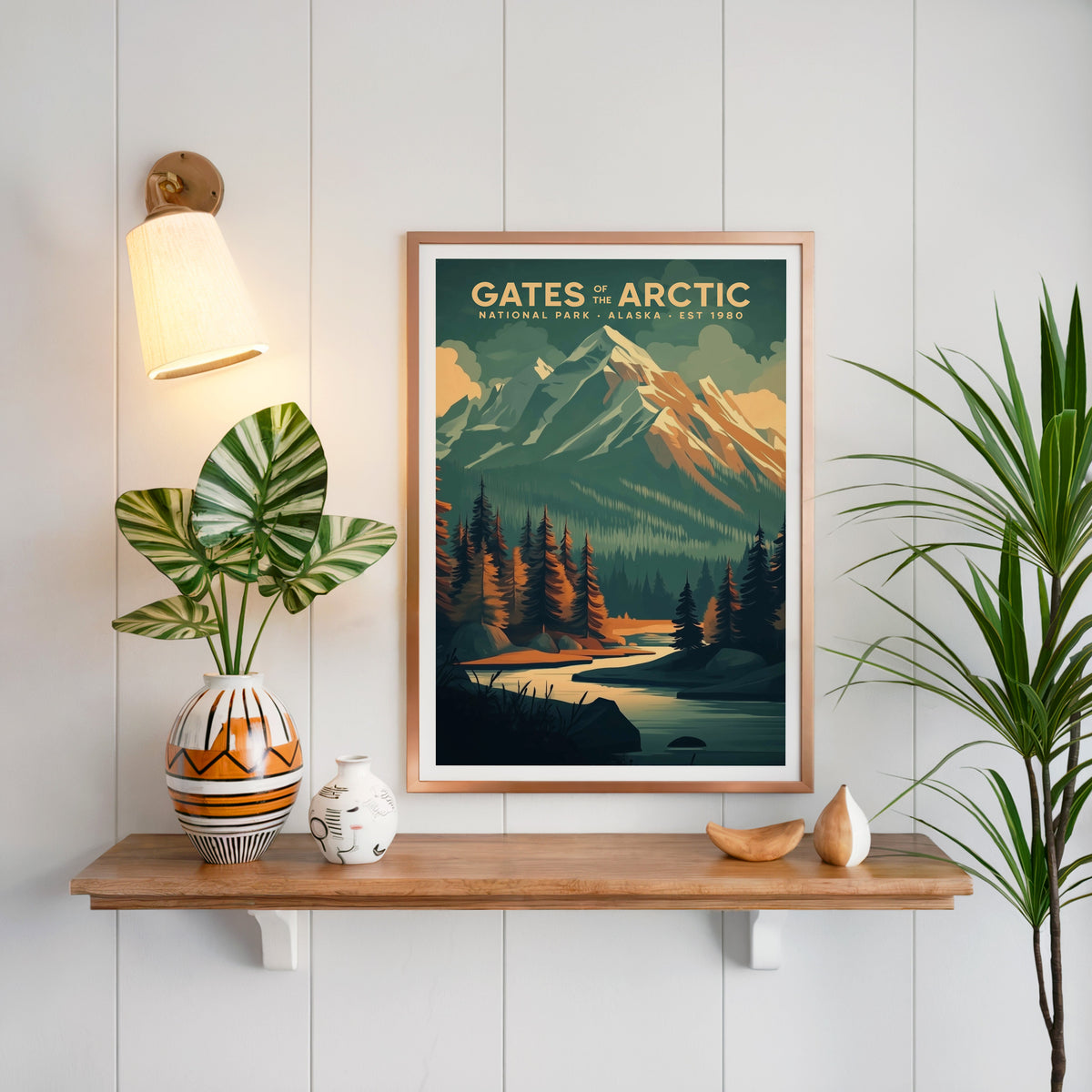 Gates of the Arctic print in a copper frame above an oak shelf on white shiplap with a sconce