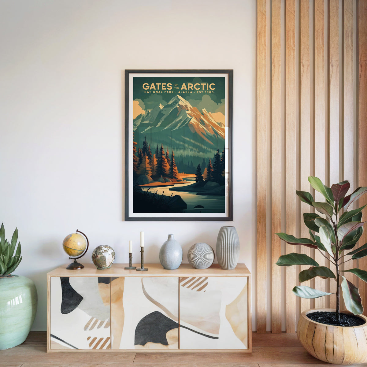 Gates of the Arctic print in a black frame above a light wood sideboard with a globe and vases