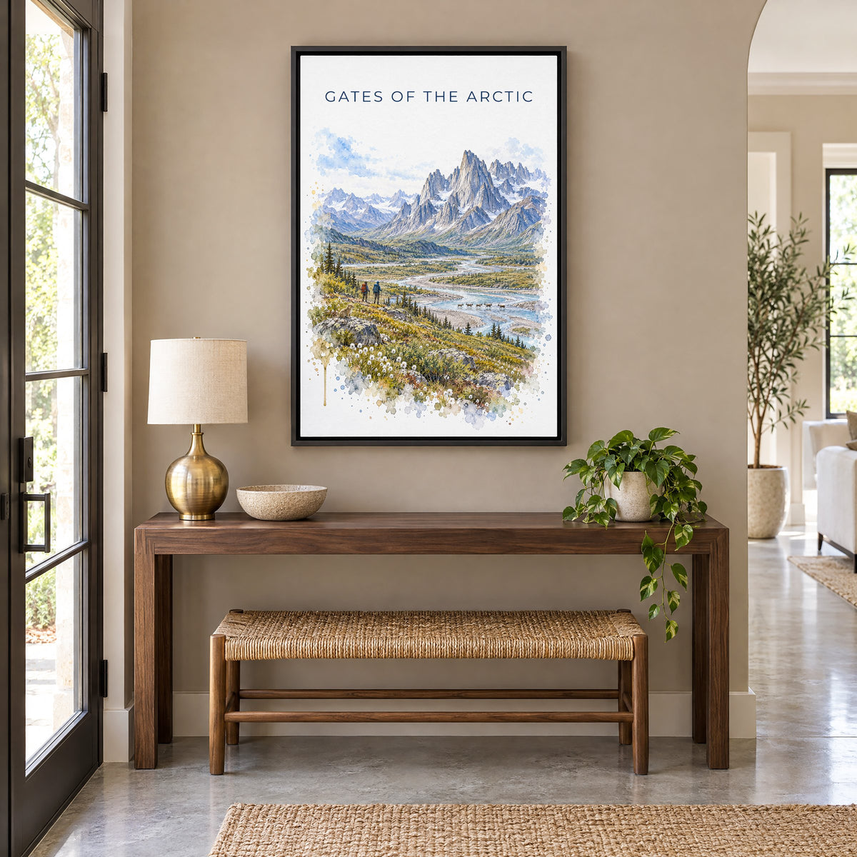 Gates of the Arctic National Park watercolor as a black floater canvas above a walnut console and woven bench in an entryway
