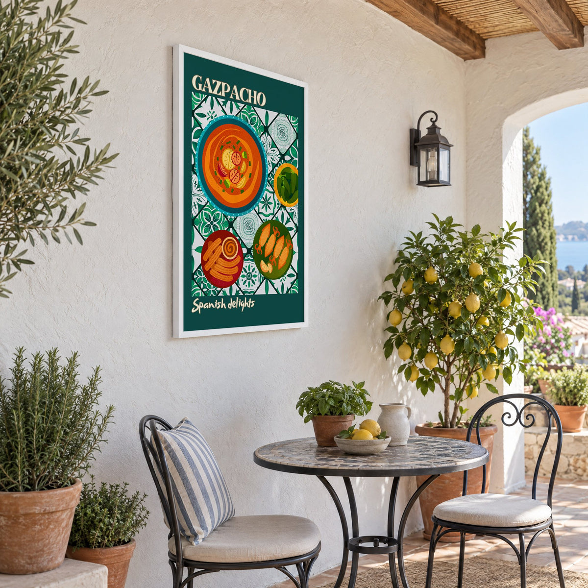 Gazpacho tapas print with teal border in a white frame on a sunny patio wall beside a potted lemon tree