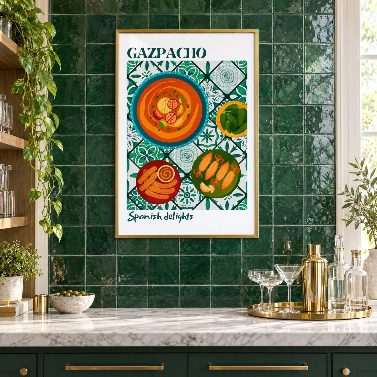 Gazpacho tapas print with white border in a brass frame on emerald green tiles above a home bar with coupe glasses