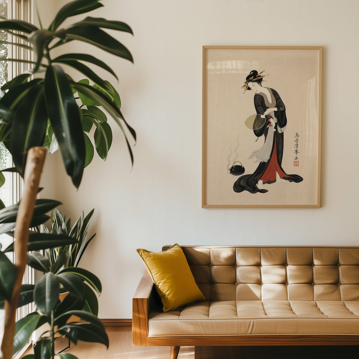 woman in black kimono with fan print in an oak frame above a tan tufted leather sofa with a mustard cushion
